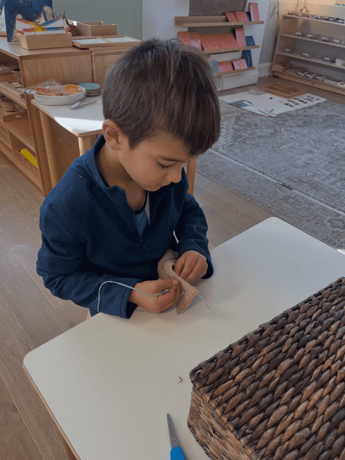 A child concentrating on Montessori work in the classroom at Beacon Montessori School in Weston, MA